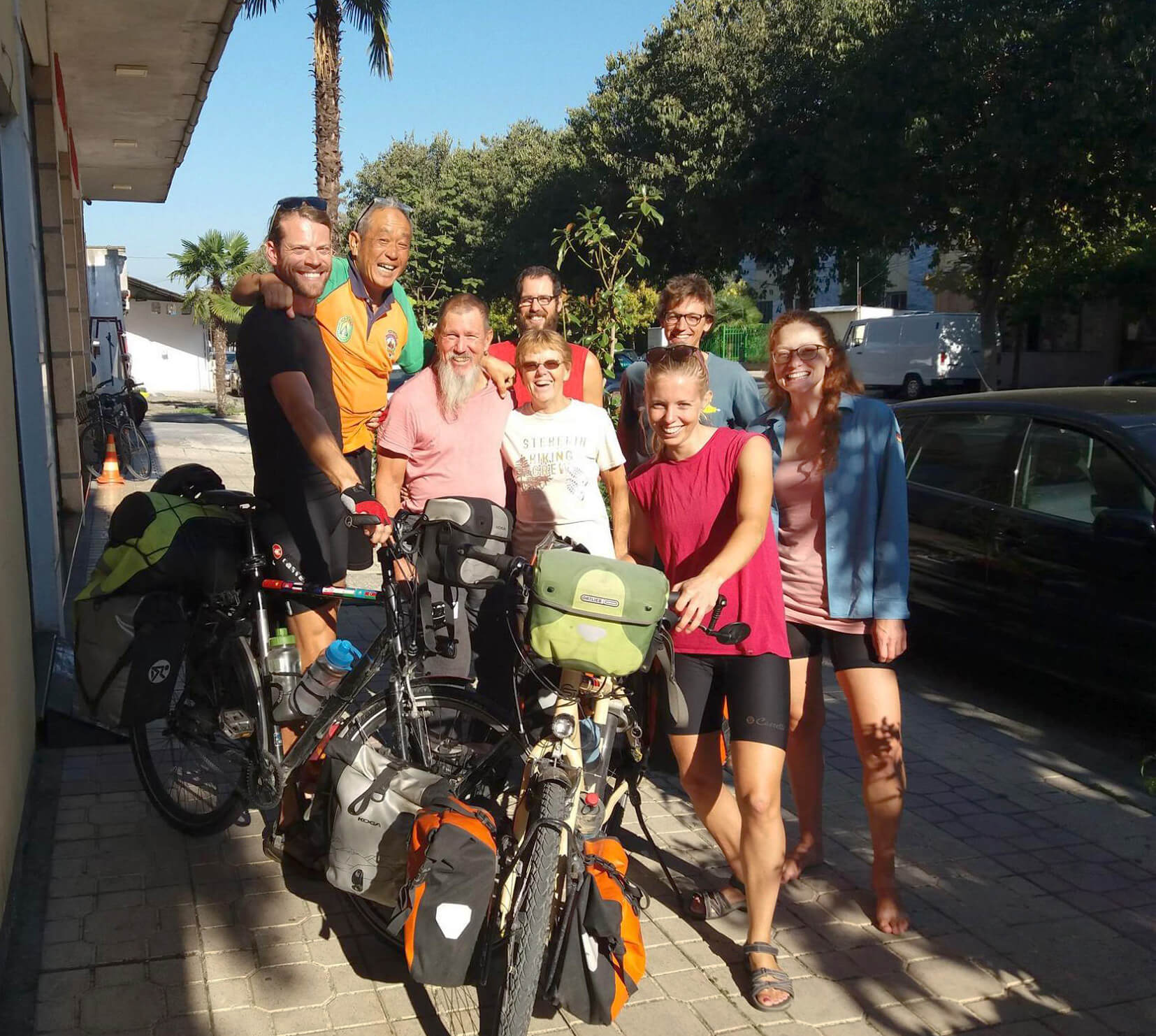 Gathering of people outside a residence with bicycles scattered around