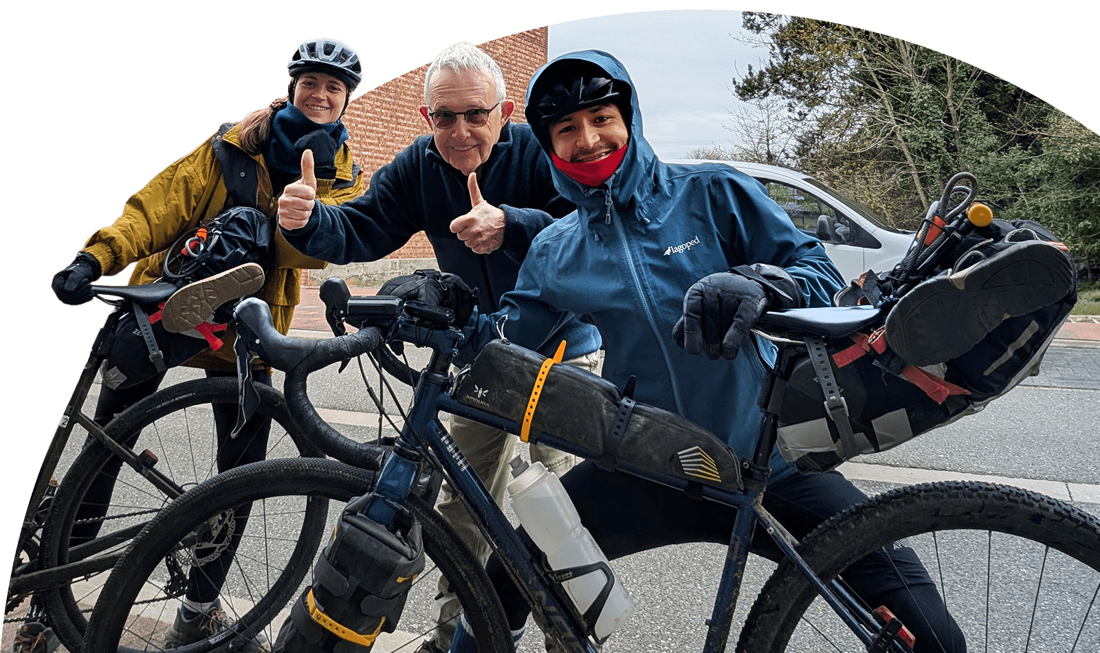 Zwei Radfahrer posieren mit einem Moderator von Warmshowers.