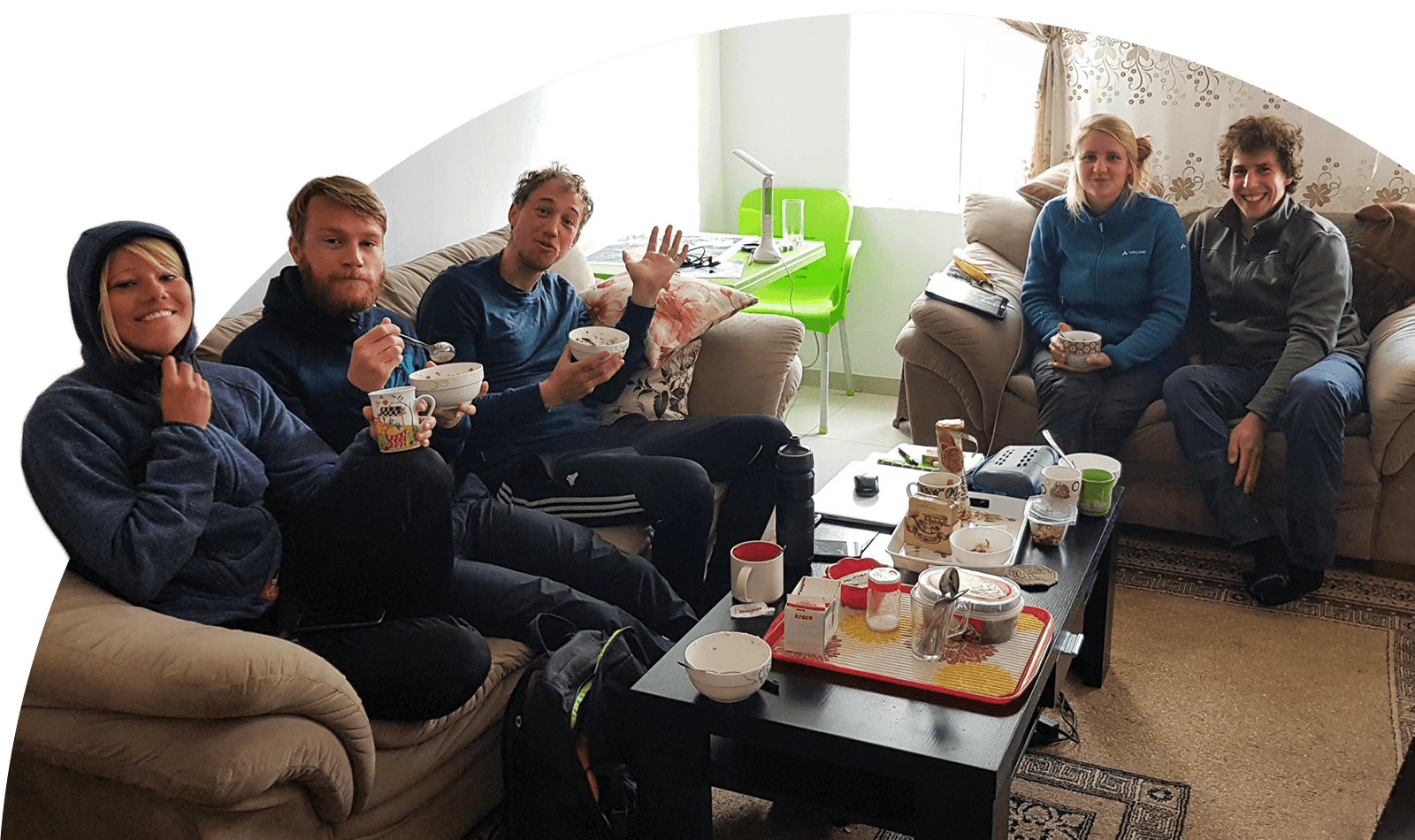 Eine Gruppe von Gästen frühstückt im Wohnzimmer des Gastgebers.